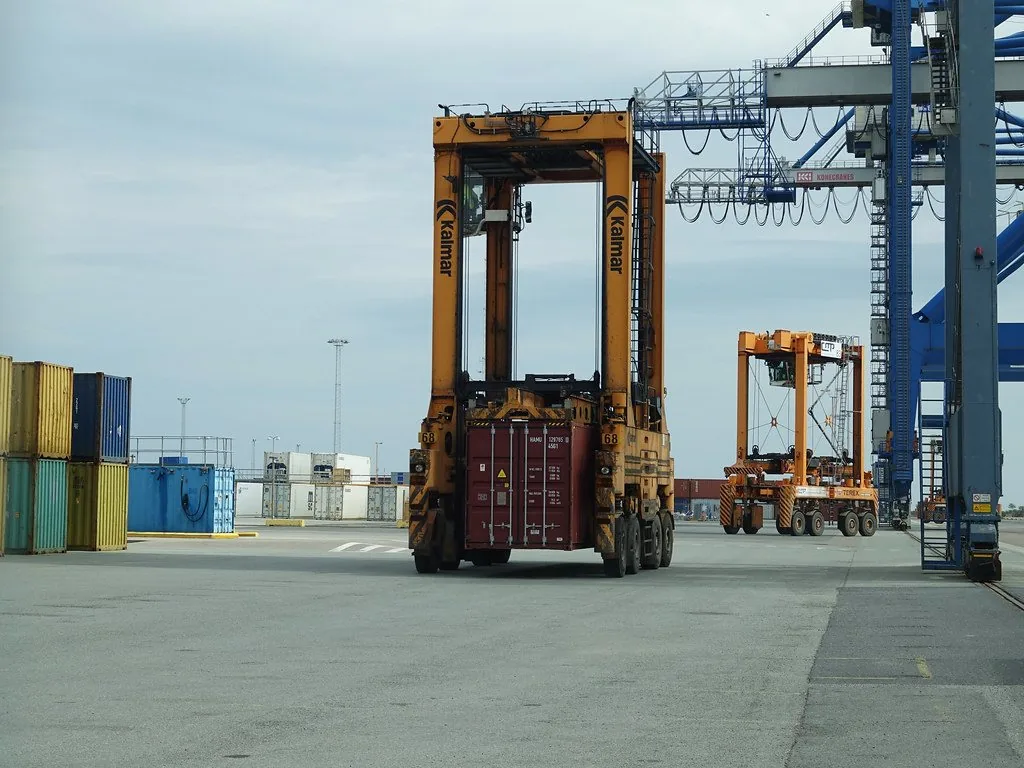 Straddle carrier moving a container across a terminal apron